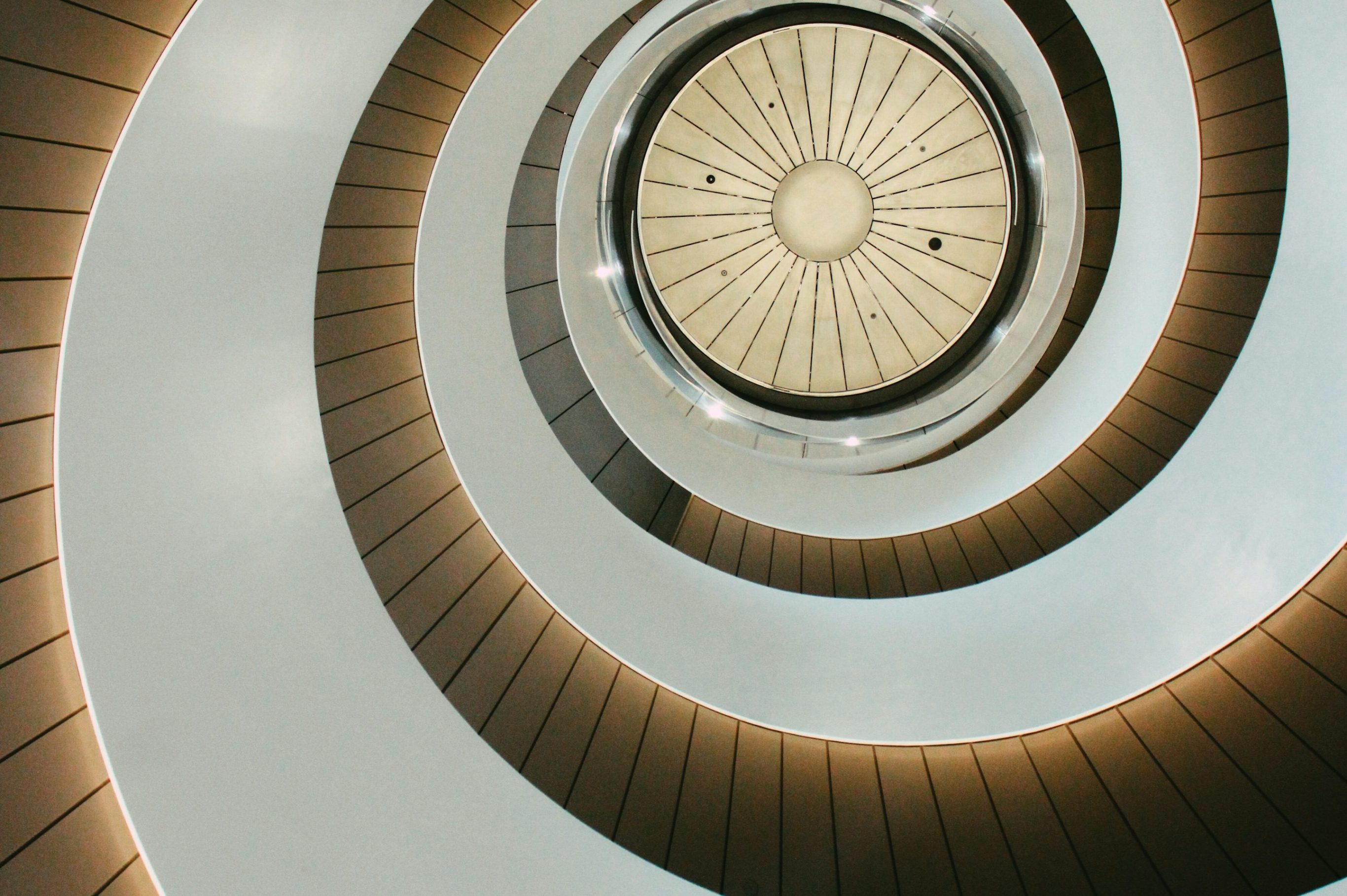 Spiraltreppe mit hellem, moderner Design und runden Lichtquellen.